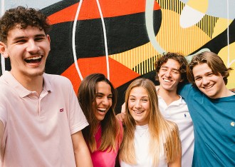 Groupe d’étudiants de l’école de commerce INSEEC rigolant devant un mur tagué et coloré à Bordeaux